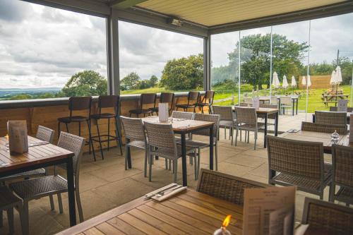 a restaurant with tables and chairs and windows at White Hart Inn in Brightling