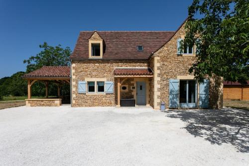 une grande maison en briques avec une grande allée. dans l'établissement Luxury 3 Bed Home with Heated Swimming Pool Air Con and Boules Pitch, à Salignac