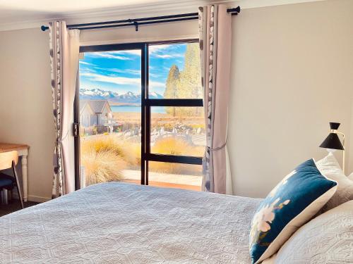 a bedroom with a bed and a large window at Alice Garden in Lake Tekapo