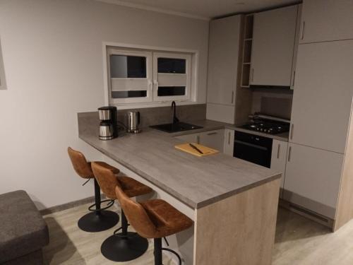 a kitchen with a island with two chairs and a counter top at Ferienhaus Seeblick - 26910 in Twist