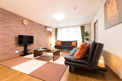 a living room with a couch and a television at come-on inn OSAKA in Osaka