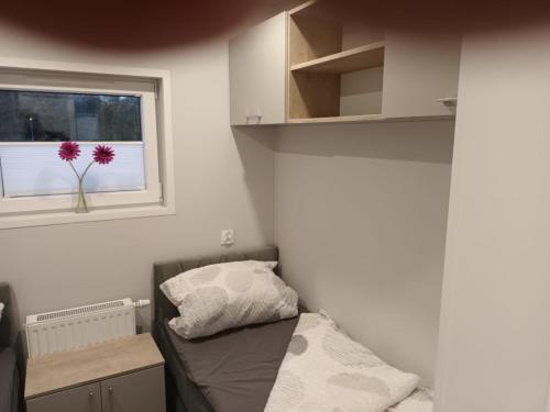 a small room with a bed and a window at Ferienhaus Seeblick - 26910 in Twist