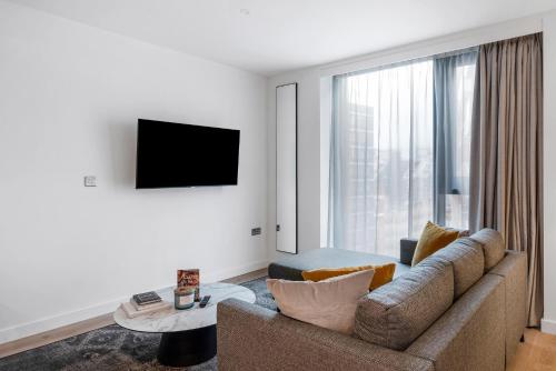 a living room with a couch and a large window at CitySuites 2 Aparthotel in Manchester
