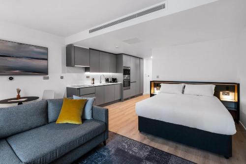 a bedroom with a bed and a couch and a kitchen at CitySuites 2 Aparthotel in Manchester