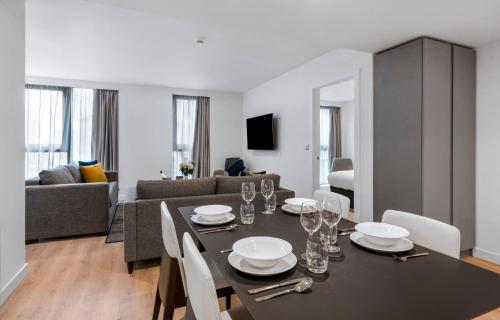 a dining room and living room with a table and chairs at CitySuites 2 Aparthotel in Manchester