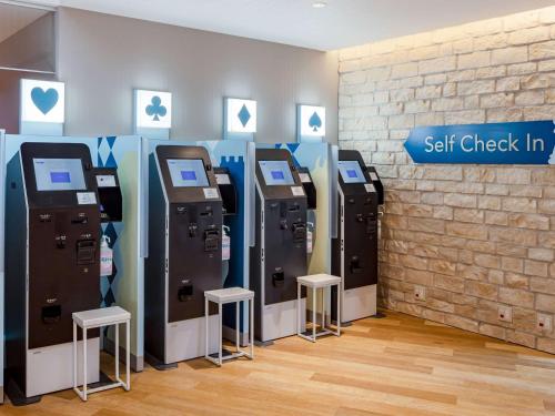 a row of self check in machines next to a wall at Comfort Suites Tokyo Bay in Tokyo