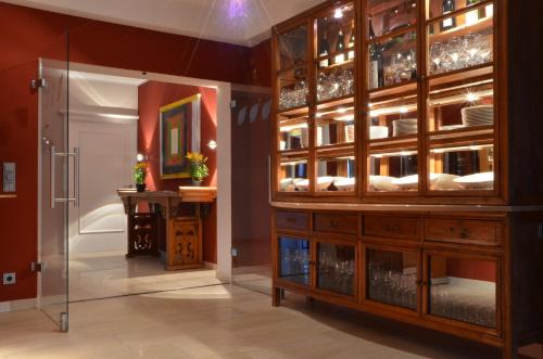 a dining room with a large wooden cabinet with glass doors at Nebelhorn Relaxhotel in Obermaiselstein