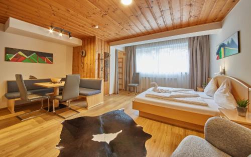 a hotel room with a bed and a table and chairs at Appartement Slope & Smile in Saalbach-Hinterglemm
