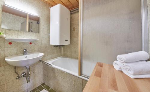 uma casa de banho com um lavatório e uma banheira em Appartement Slope & Smile em Saalbach-Hinterglemm