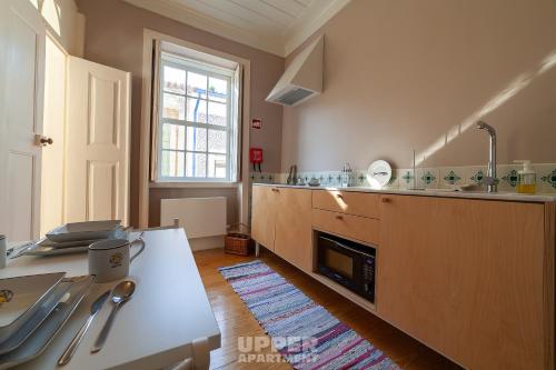 eine große Küche mit einer Theke und einem Waschbecken in der Unterkunft Casinhas da Beira Mar by Home Sweet Home Aveiro in Aveiro