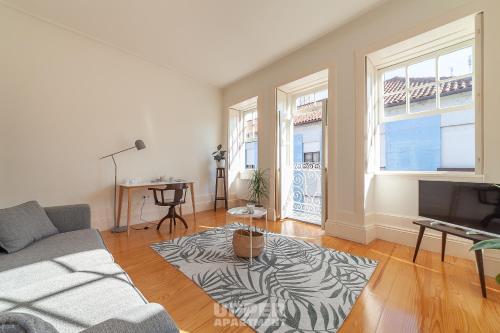 a living room with a couch and a television at Casinhas da Beira Mar by Home Sweet Home Aveiro in Aveiro