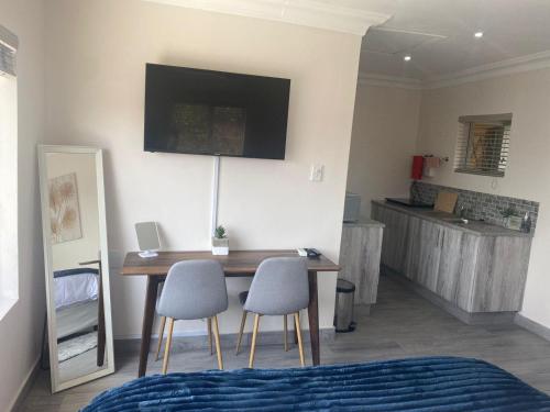 a room with a table and two chairs and a kitchen at 14 on Braemar in Durban