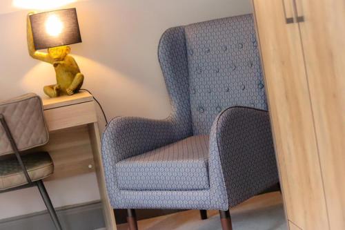 a blue chair next to a desk with a lamp at The Strutt Arms in Belper