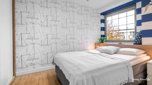 a bedroom with a mural of sailboats on the wall at Apartament 117 HVILE in Gdańsk