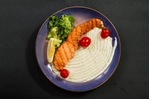 a plate of food with fish and vegetables on it at Готель Релакс in Korostyshiv