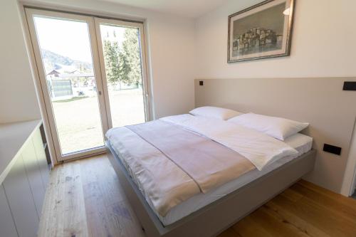 a bed in a room with a large window at Maison du Soleil in Kranjska Gora
