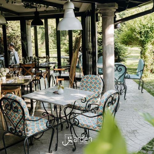 a patio with tables and chairs on a patio at Hotel Garden in Pristina