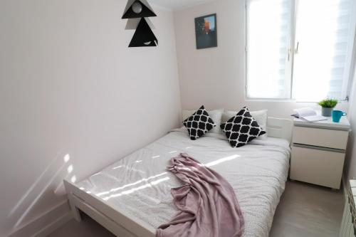 a small bedroom with a bed with white sheets and pillows at Old Town Apartments Sandomierz in Sandomierz
