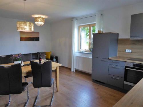 a kitchen with a wooden table and a table and chairs at Ferienwohnung Sonnenplatzl in Michelsneukirchen