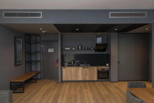 a room with a kitchen and a table and a bench at mk hotel tirana in Tirana