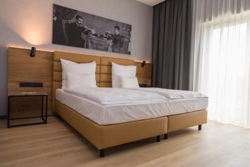 a bedroom with a large bed with white sheets at mk hotel tirana in Tirana