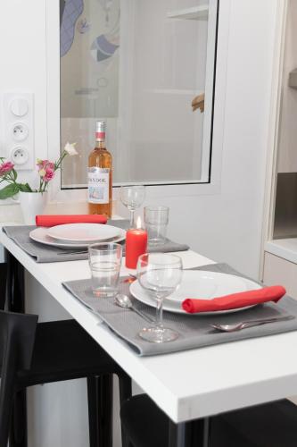 une table avec une bougie rouge, des assiettes et des verres dans l'établissement Residence le Pastel Jeanne d'Arc, à Toulouse