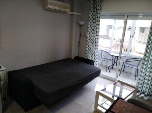 Habitación pequeña con cama y mesa con sillas. en Apartament Goleta en Torrevieja