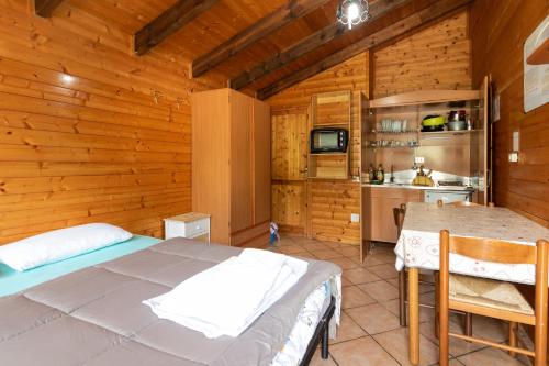 a bedroom with a bed and a kitchen in a cabin at Parco Del Sangro in Castel di Sangro