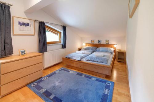 a bedroom with a bed and a blue rug at Haus Lowe Appartement 2 Stock Nr 4 in Filzmoos