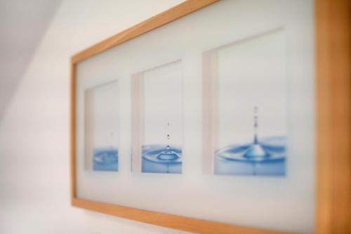 a picture frame on a wall with three pictures of water at Haus Lowe Appartement 2 Stock Nr 4 in Filzmoos