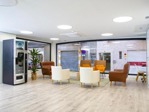 an office with a waiting room with chairs and tables at Hotel Azahar in Murcia