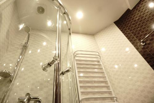 y baño con ducha y escalera. en Doba In Ua Most-Sity Apartments, en Dnipro