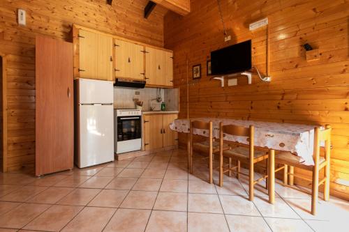 a kitchen with a refrigerator and a table with chairs at Parco Del Sangro in Castel di Sangro
