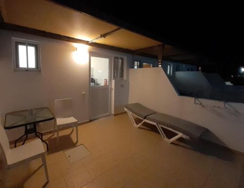 a room with a bench and a table and a staircase at Delphini Studios - for the disabled in Kefalos