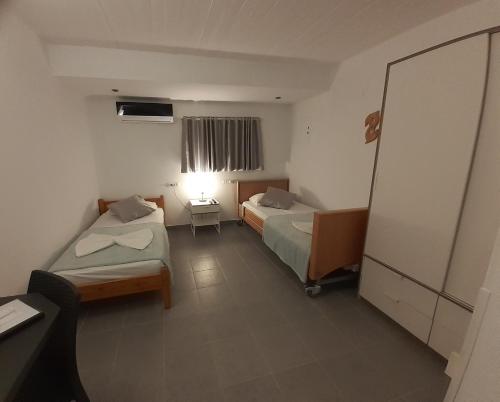 a hotel room with two beds and a mirror at Delphini Studios - for the disabled in Kefalos
