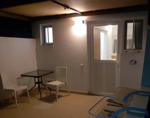 a room with a table and chairs and a door at Delphini Studios - for the disabled in Kefalos