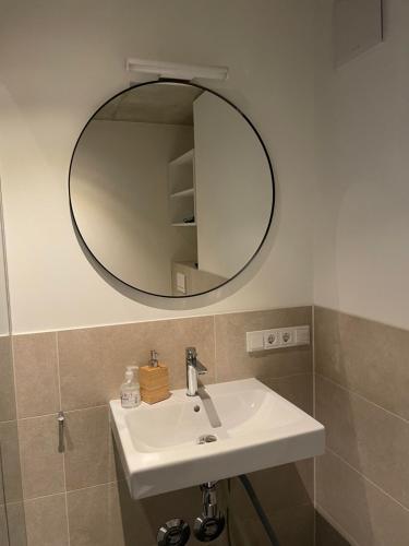 Un baño con un lavabo blanco y un espejo. en Int. Appartment Kolbermoor, en Kolbermoor