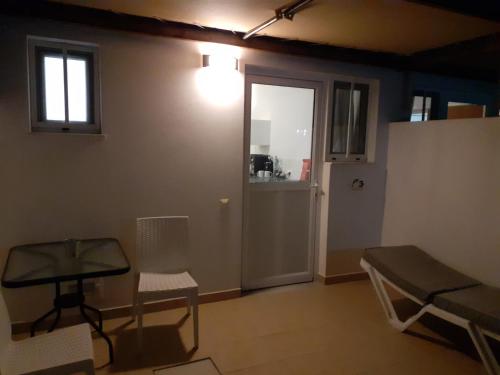 a room with a table and a chair and a door at Delphini Studios - for the disabled in Kefalos