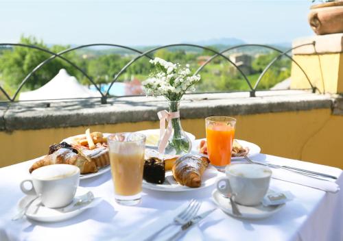 a table with a plate of breakfast food and drinks at Hotel Villa Cariola in Caprino Veronese