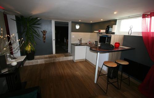 a kitchen with a counter and stools in a room at Le Boudoir de Cormelles in Cormelles