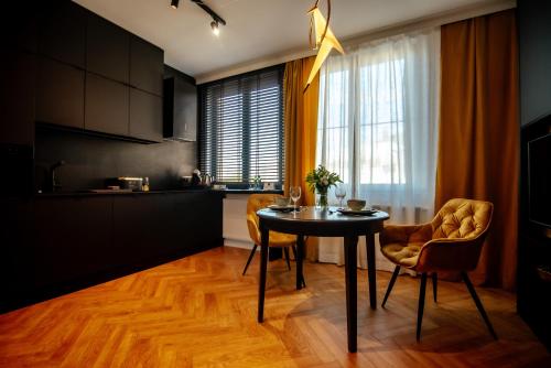 - une cuisine avec une table et des chaises dans la chambre dans l'établissement Apartamenty Stare Miasto Zamość, à Zamość