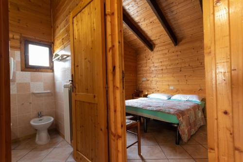 ein Schlafzimmer mit einem Bett in einer Holzhütte in der Unterkunft Parco Del Sangro in Castel di Sangro