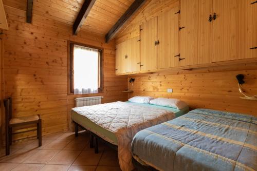 a bedroom with two beds in a log cabin at Parco Del Sangro in Castel di Sangro