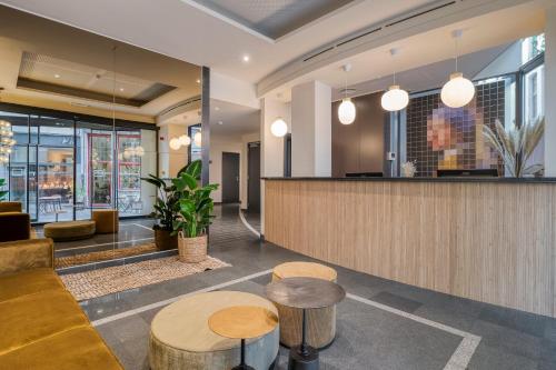 a lobby with a bar and some tables and chairs at Alma Grand Place Hotel in Brussels