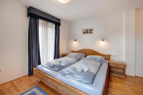 a bedroom with a bed with blue sheets and a window at Haus Lowe Appartement 1 Stock Nr 2 in Filzmoos