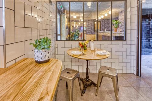 a restaurant with a table and two stools and a table at Eklo Hotels Le Havre in Le Havre