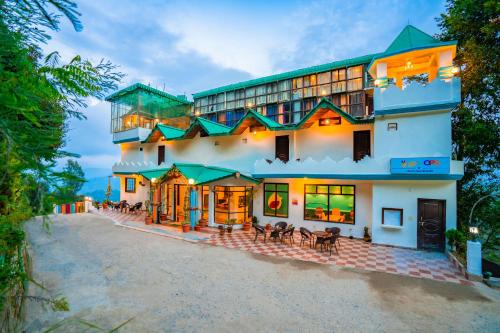 un gran edificio blanco con techos verdes en goSTOPS Mukteshwar, en Mukteshwar