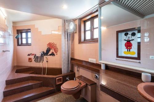 a bathroom with a toilet and a sink at StayVista's Shantam House - Dive into relaxation with a pool and tennis lawn in Lonavala