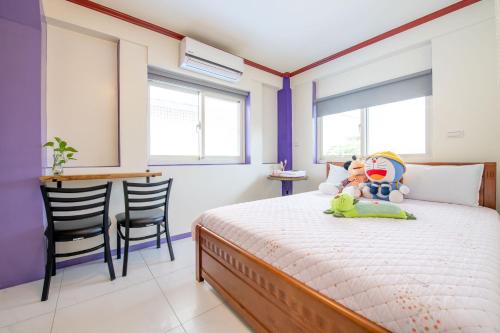 a bedroom with a bed with stuffed animals on it at 田心民宿 in Dongshan
