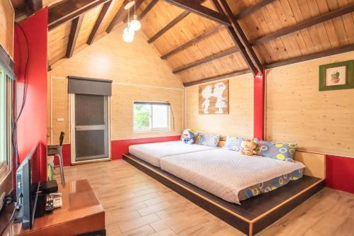 冬山鄉的住宿－田心民宿，一间设有床铺的卧室,位于一个红色墙壁的房间